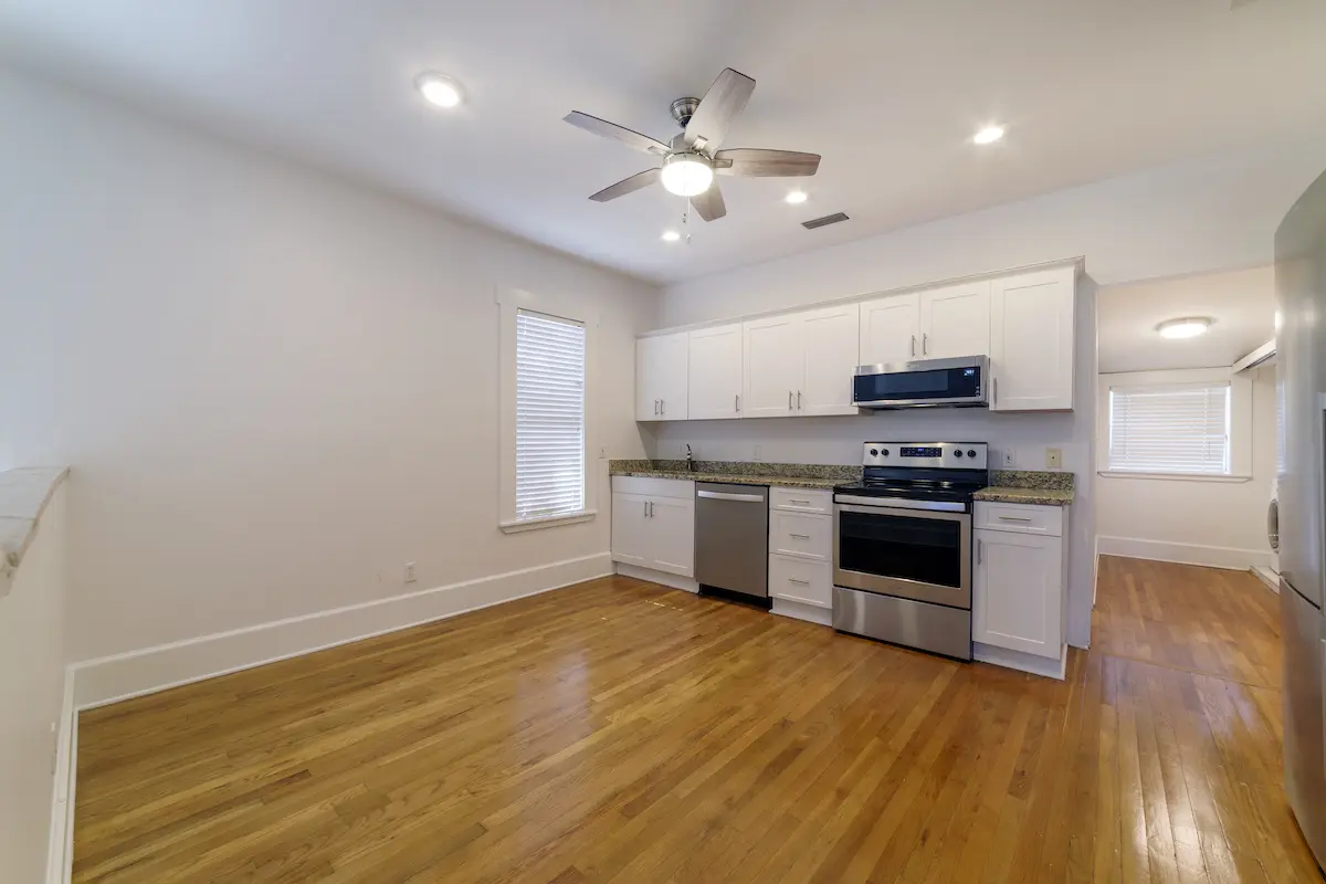 Open kitchen with hardwood floors, white cabinets, and stainless steel appliances with text overlay stating "SPECIAL."