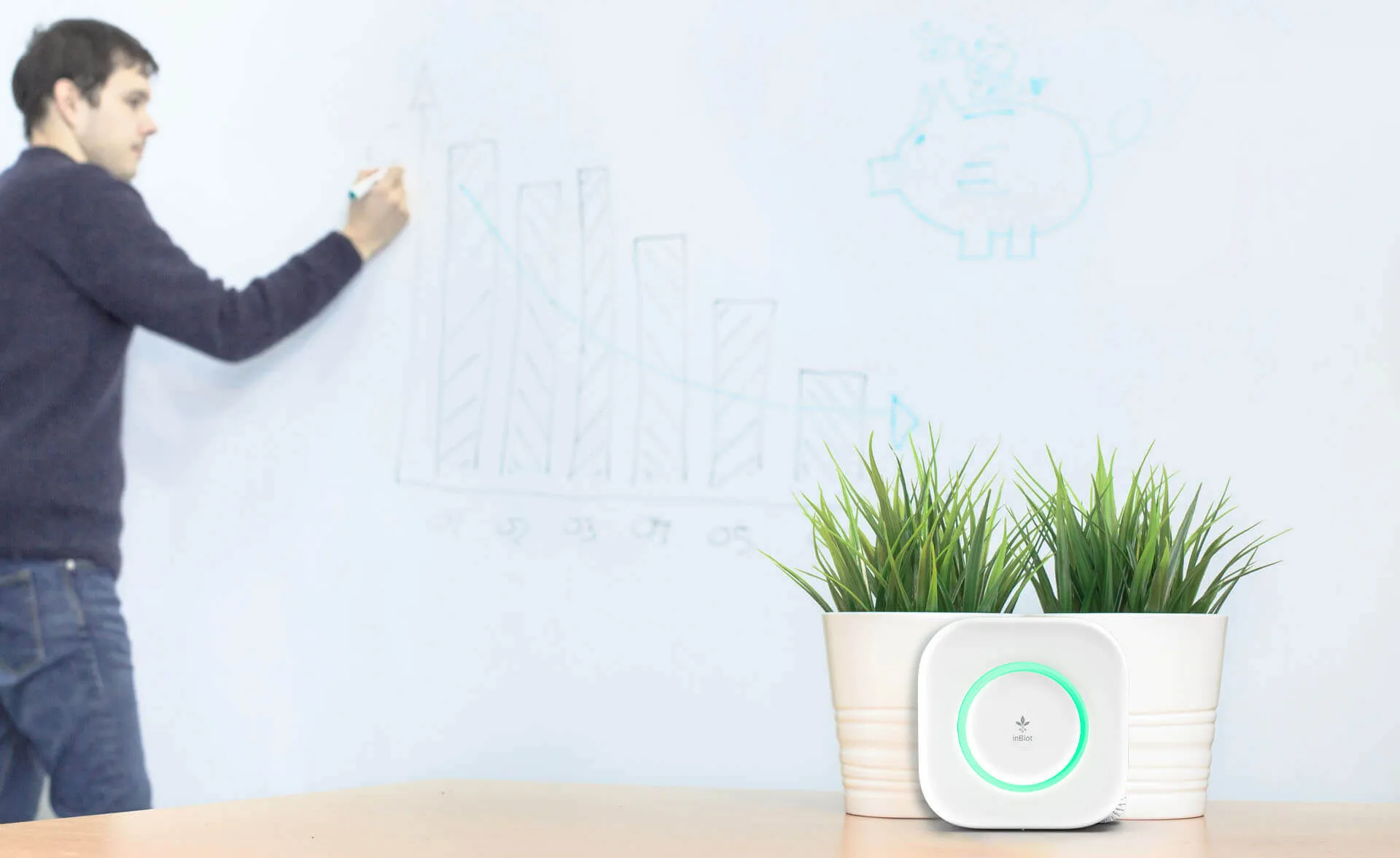 Persona haciendo cálculos en una pizarra junto a una mesa donde se encuentra el dispositivo MICA Lite