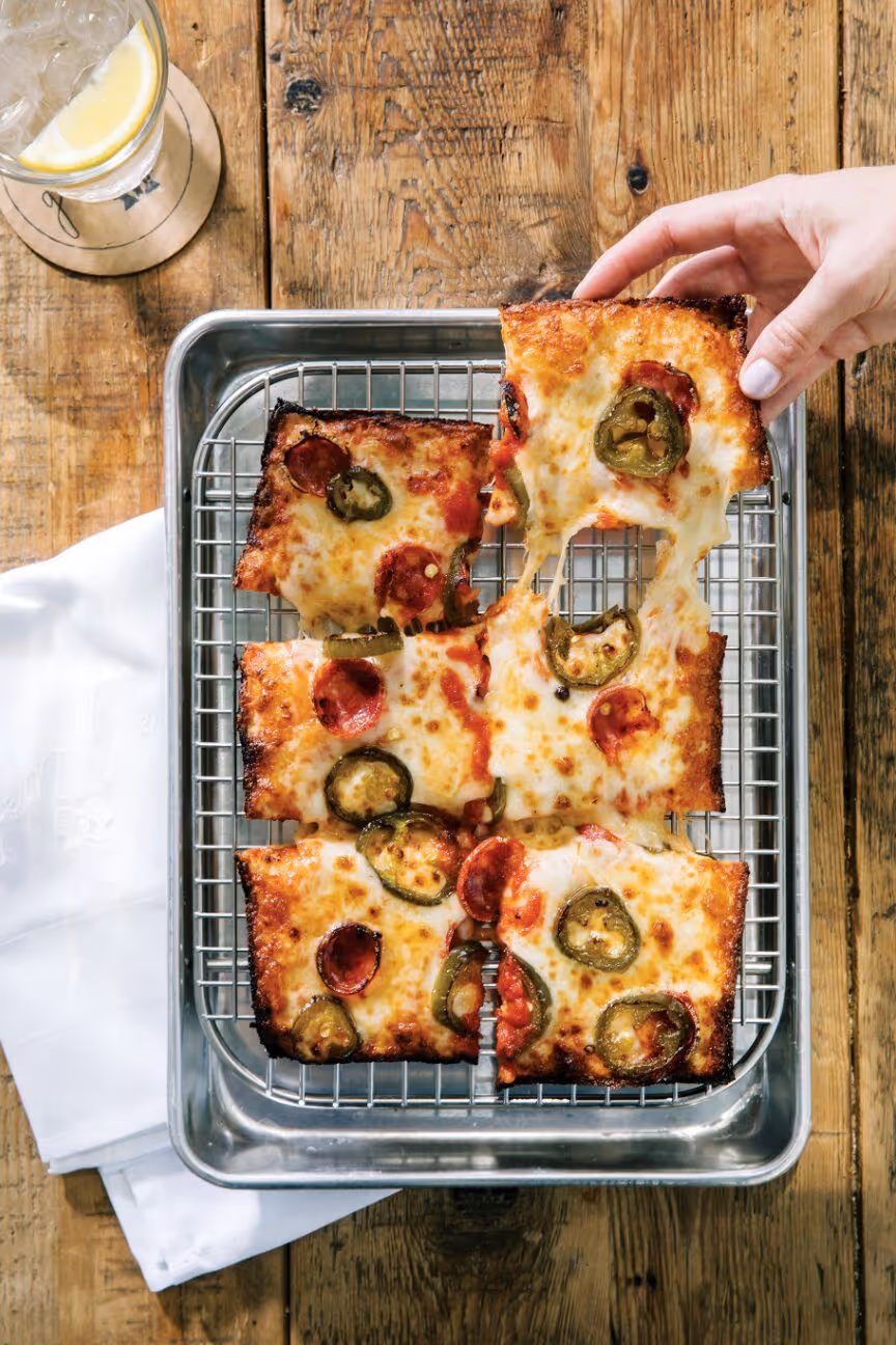 Detroit-style pizza with pepperoni and jalapeños on a wire rack served on a sheet pan at Gemelle