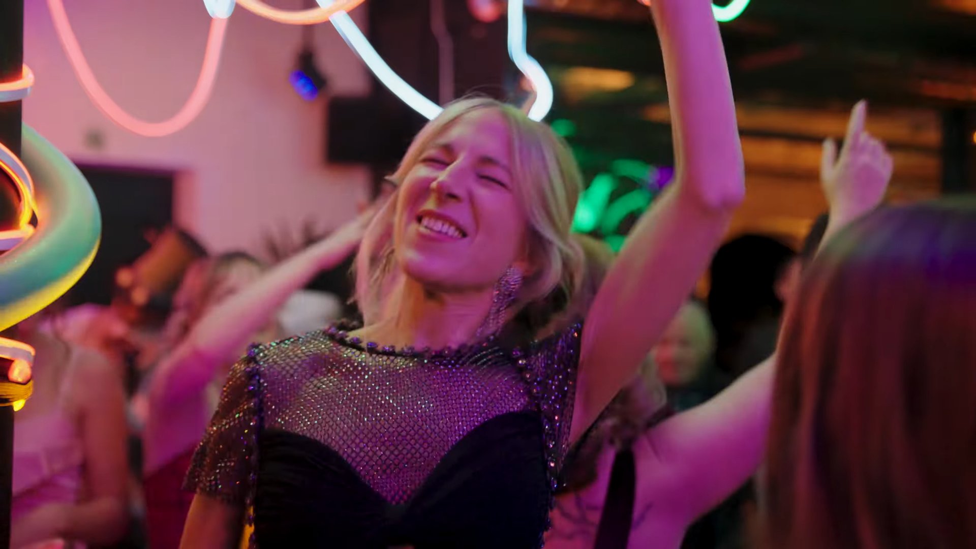 A guest dancing under neon lighting