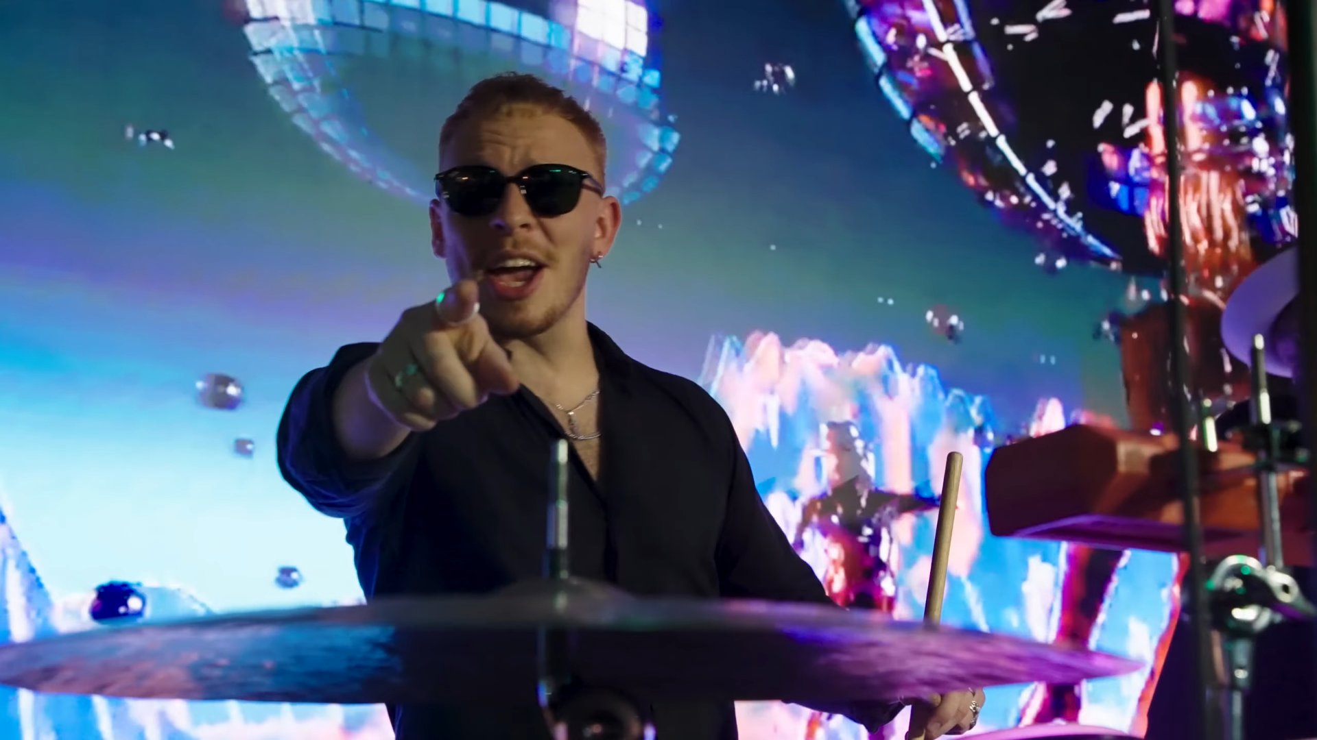 Live band drummer under mirror-ball visuals