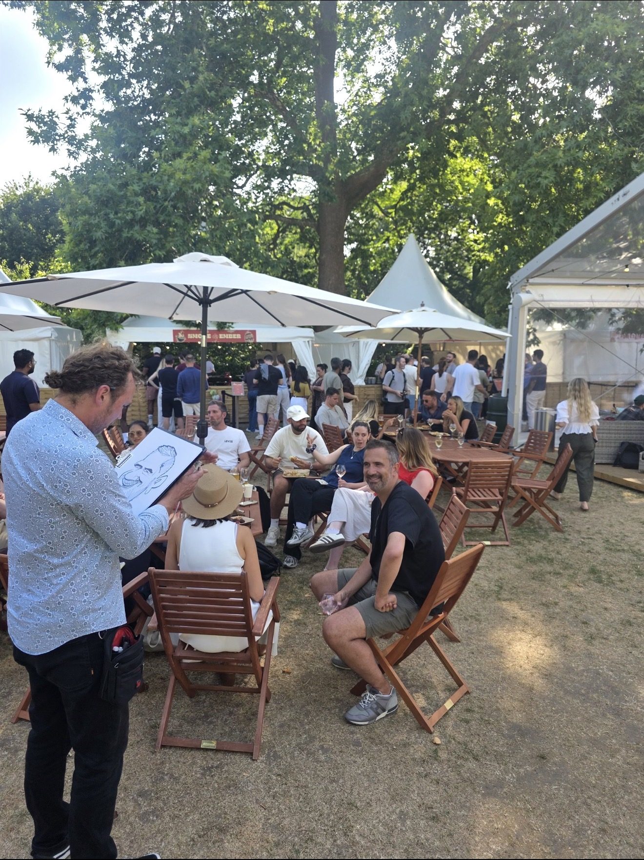 A live caricaturist creating personalised keepsakes for guests at the Monday.com summer party
