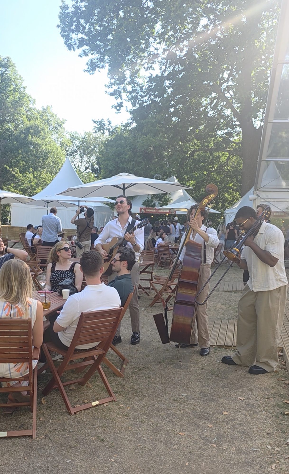 A roaming trio performing live music to seated guests during the Monday.com summer party