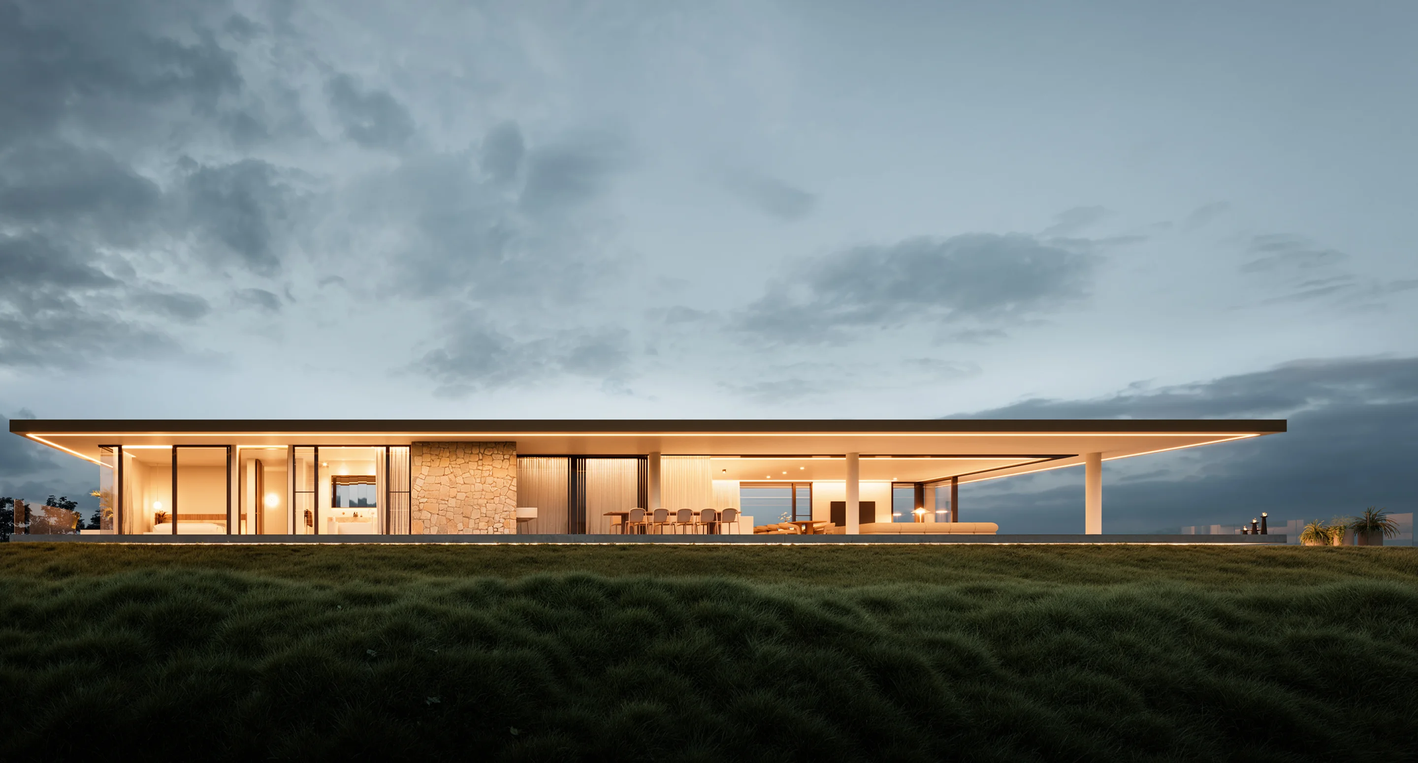 Modern single-story house with large glass windows, stone wall, and warm interior lighting at dusk.