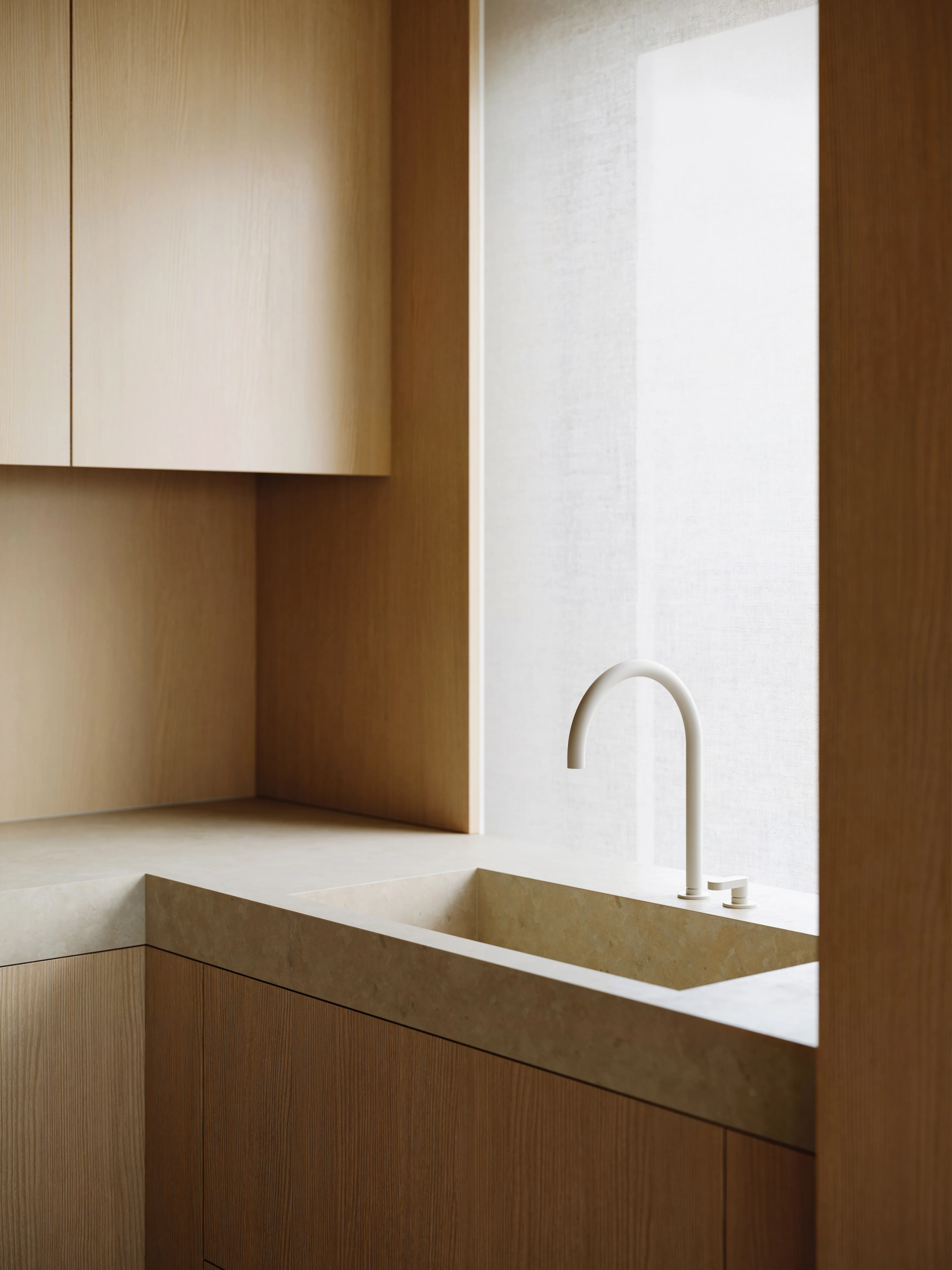 Minimalist kitchen corner with light wood cabinets, beige stone countertop, and white modern faucet by a window with sheer curtain.