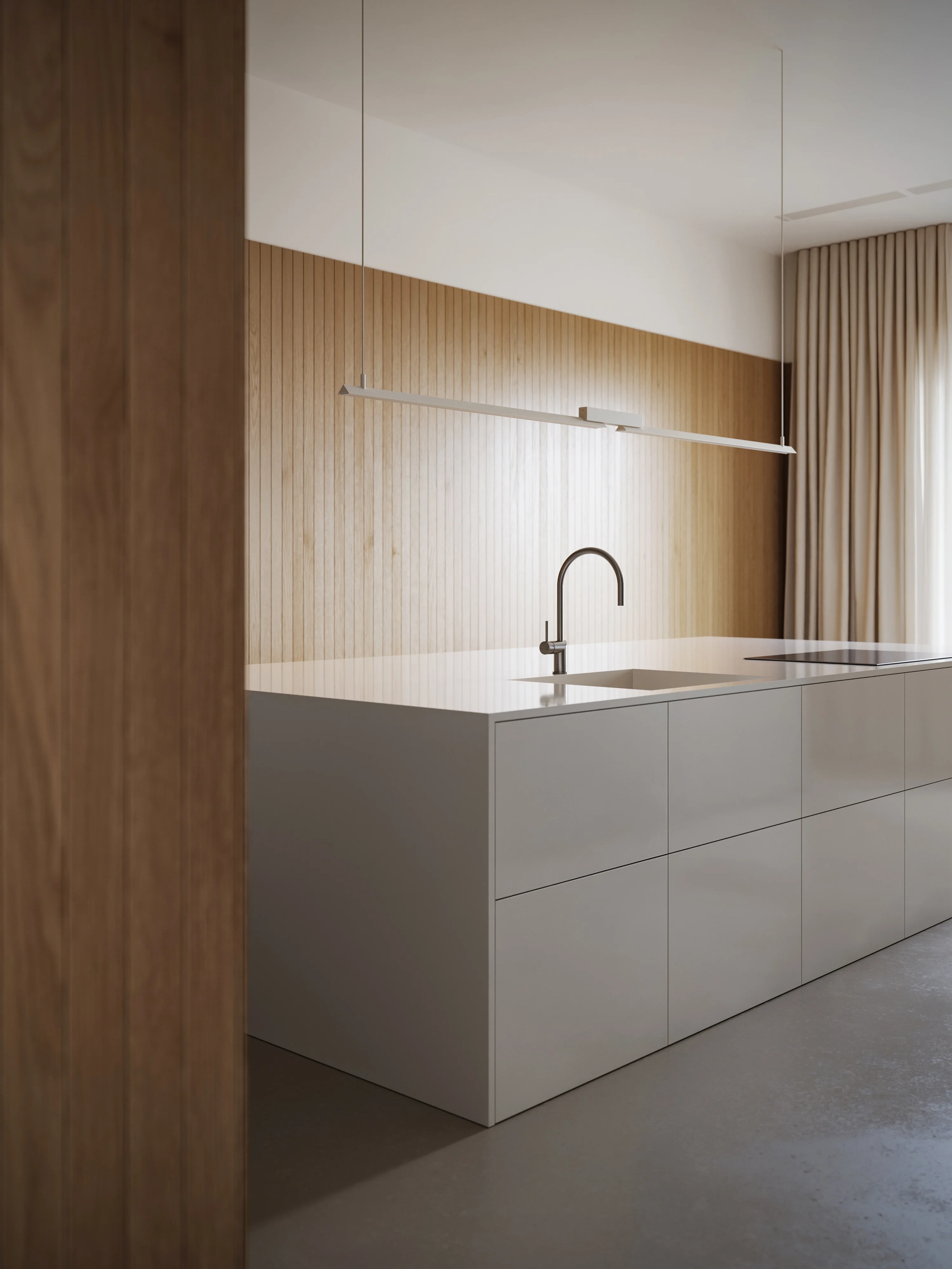 Modern minimalist kitchen with a white island, integrated sink, sleek faucet, wood panel backsplash, and hanging linear light fixture.