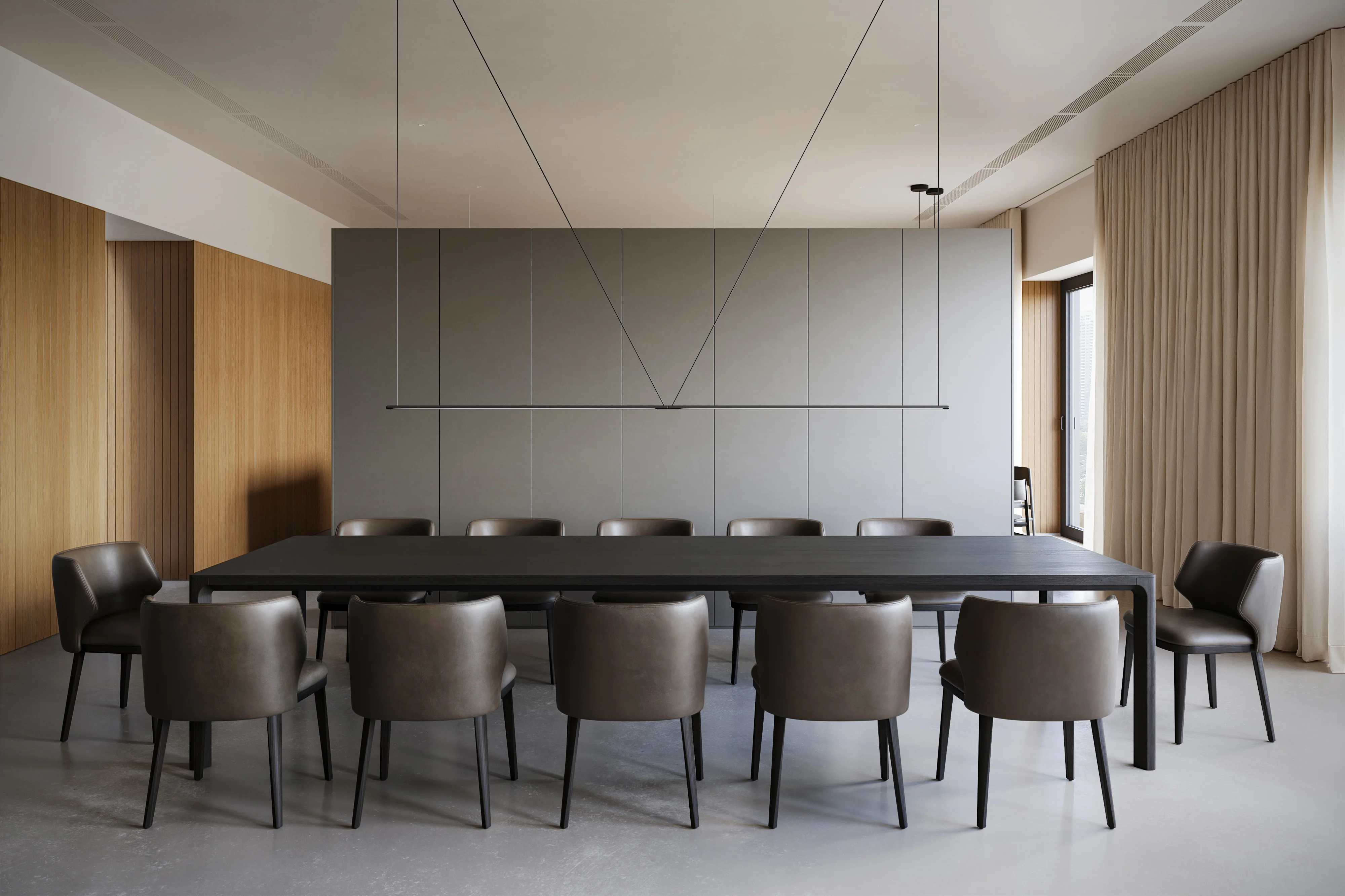Minimalist conference room with a long black table surrounded by twelve gray leather chairs and a modern linear pendant light above.