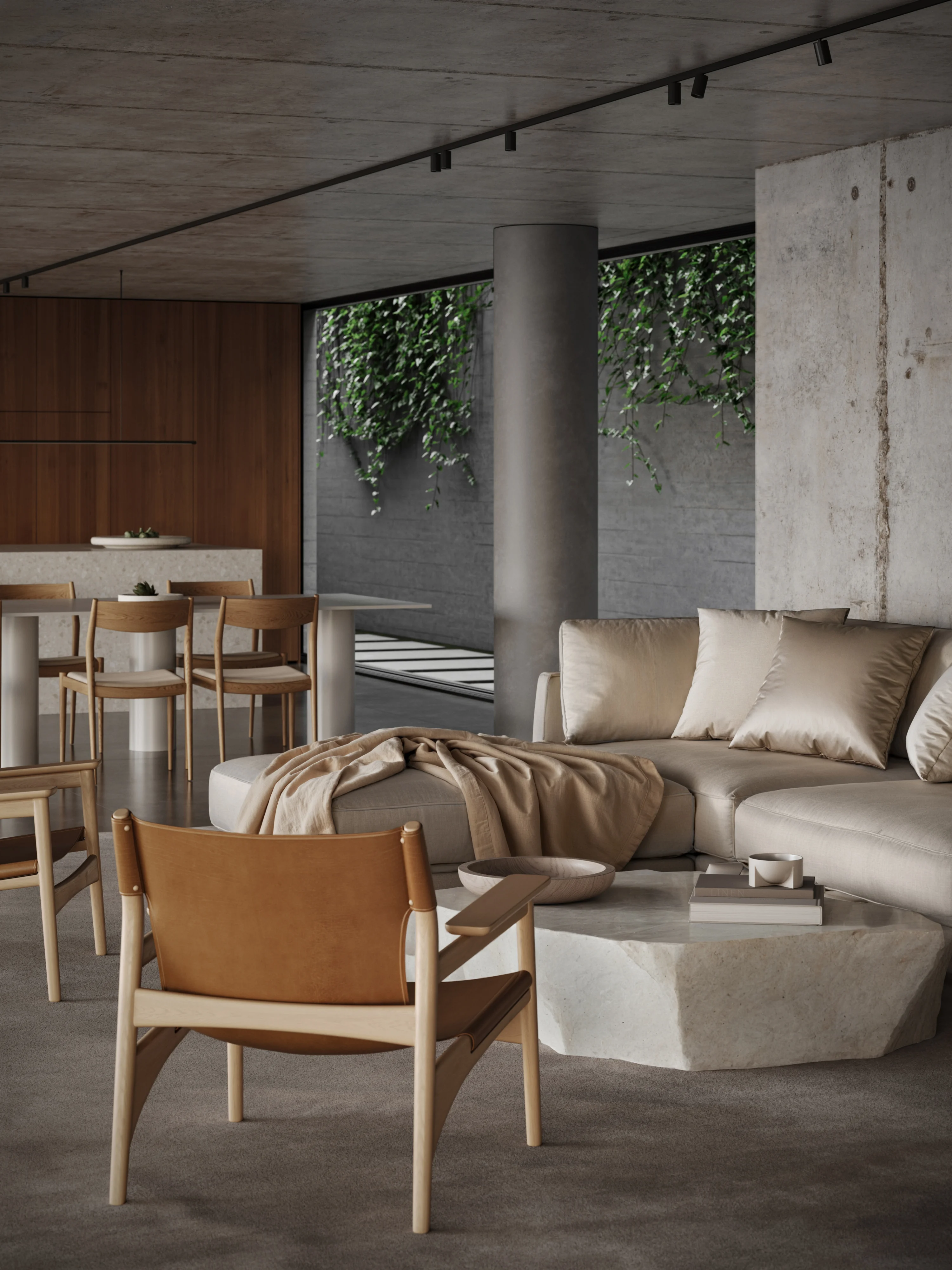 Modern living room with a beige sectional sofa, leather armchairs, stone coffee table, and dining area with wooden chairs against a backdrop of concrete and wood walls and greenery.