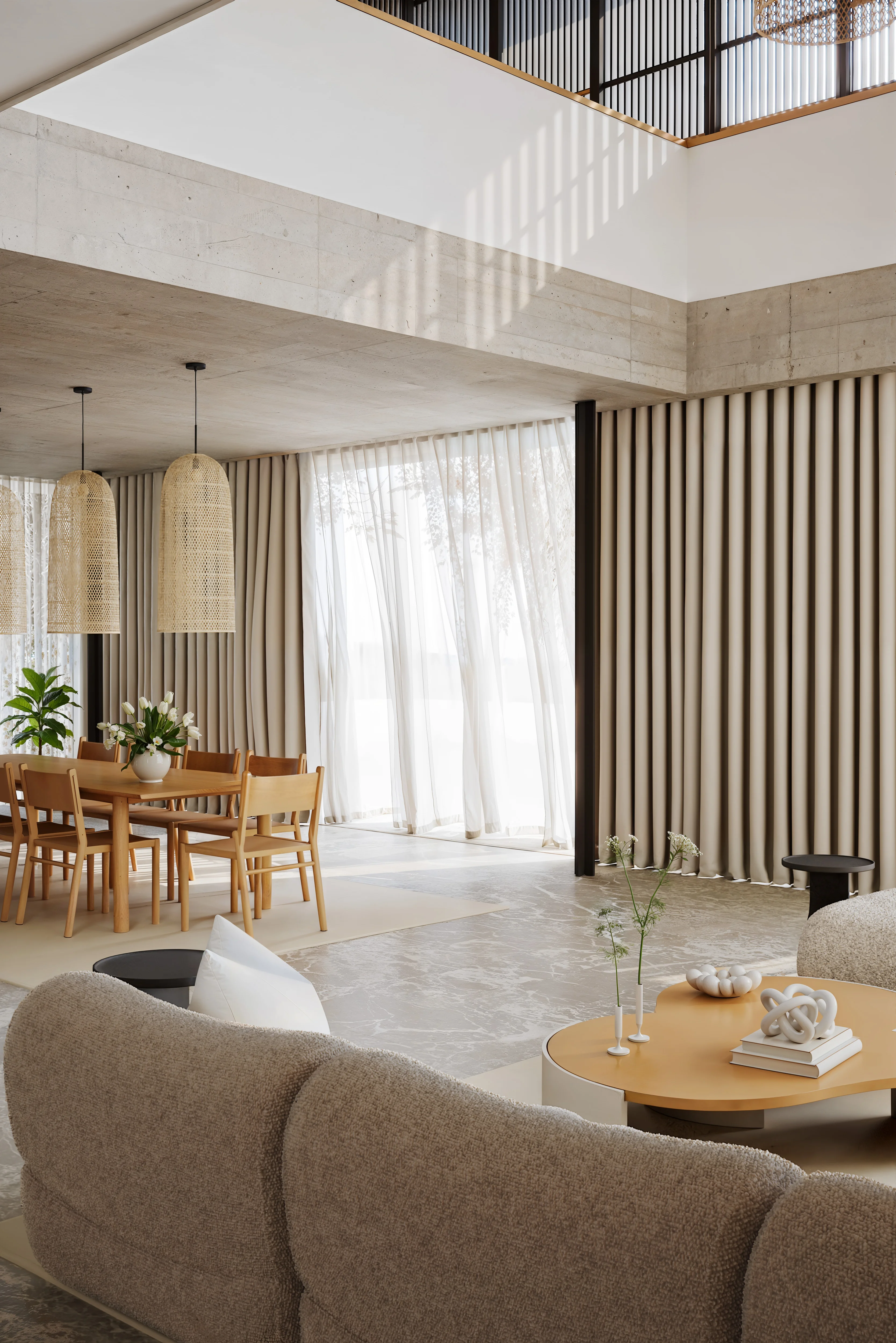 Modern living room with beige textured sofa, light wood coffee table with decorative objects, and a dining area with wooden chairs and hanging wicker lamps under a concrete ceiling beam.