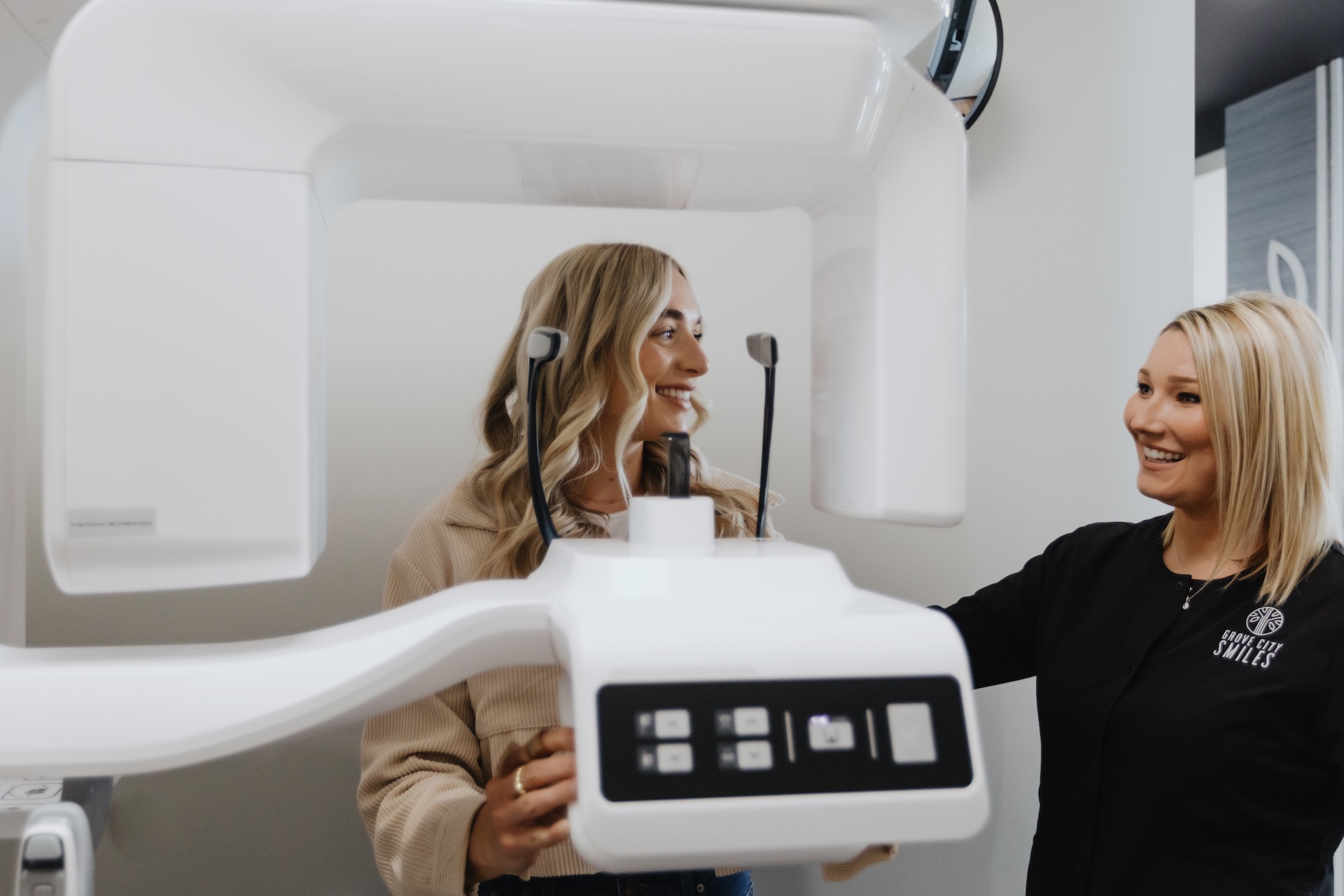 Dental assistant guides patient into cone beam CT scanner for a 3D dental image.