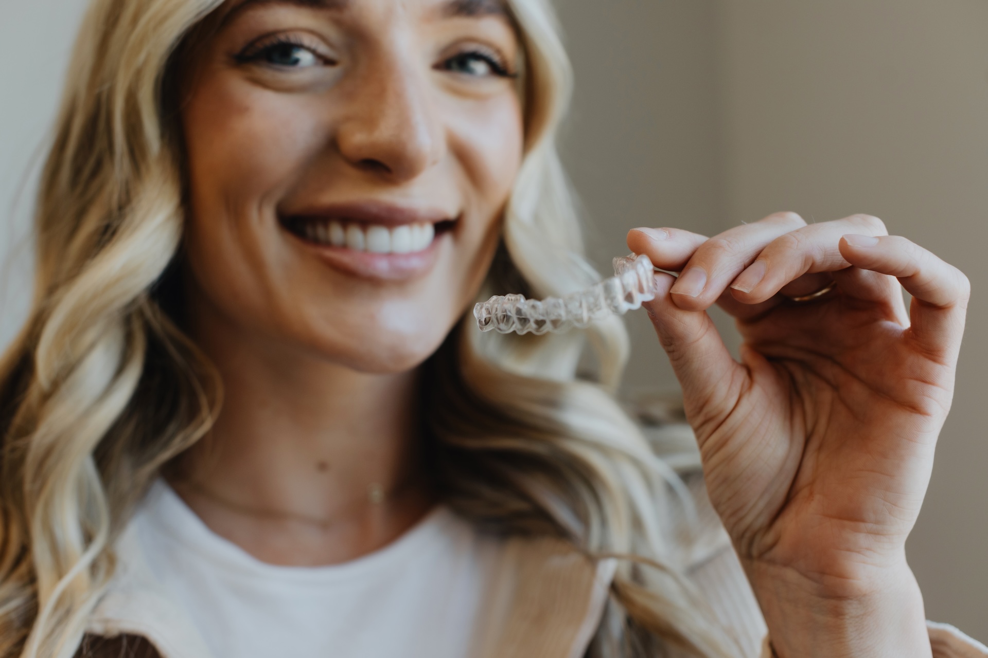 Patient at Grove City Smiles Holding up Invisalign