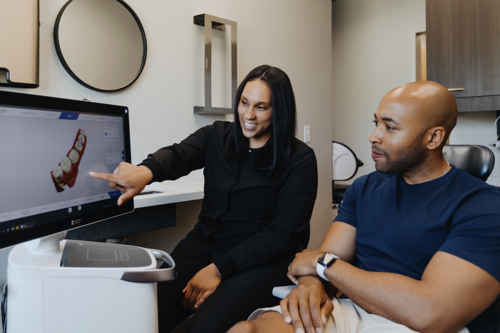 Dentist reviews digital tooth model with patient on chairside monitor
