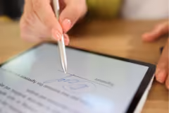 Mano firmando en tablet