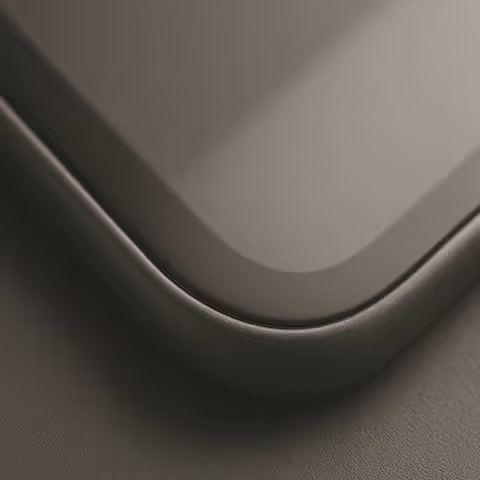 Close-up of a curved corner of a sleek, modern device with a smooth dark surface.