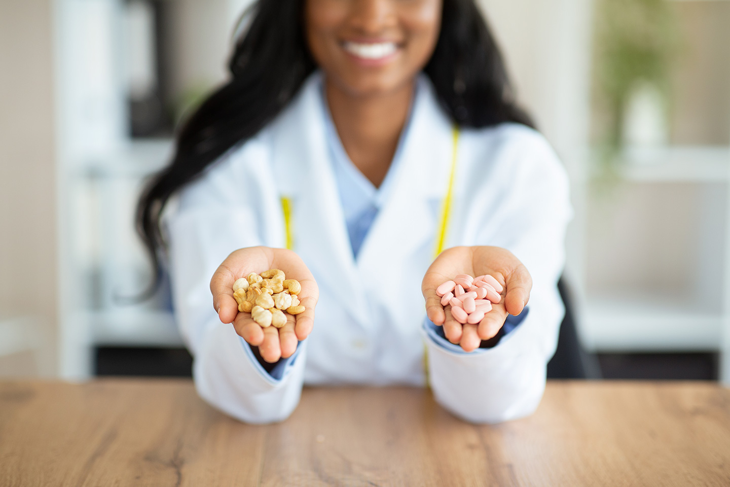 A woman in a lab coat holding nuts in one hand and tablets in the other to represent naturally-derived nutraceuticals