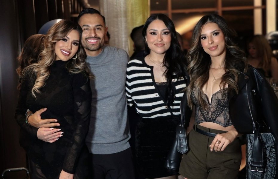 Venessa Patino stands with three other guests, smiling in a group photo at the holiday event.