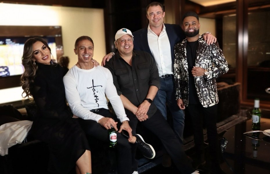 Venessa Patino sits on a couch with four male guests, all smiling, during the holiday celebration at Red Rock Casino.