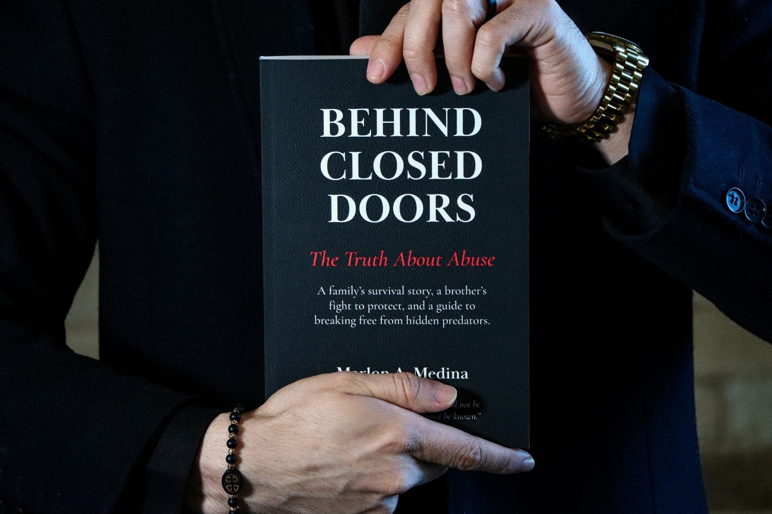 Detail shot of Behind Closed Doors book cover held at chest level