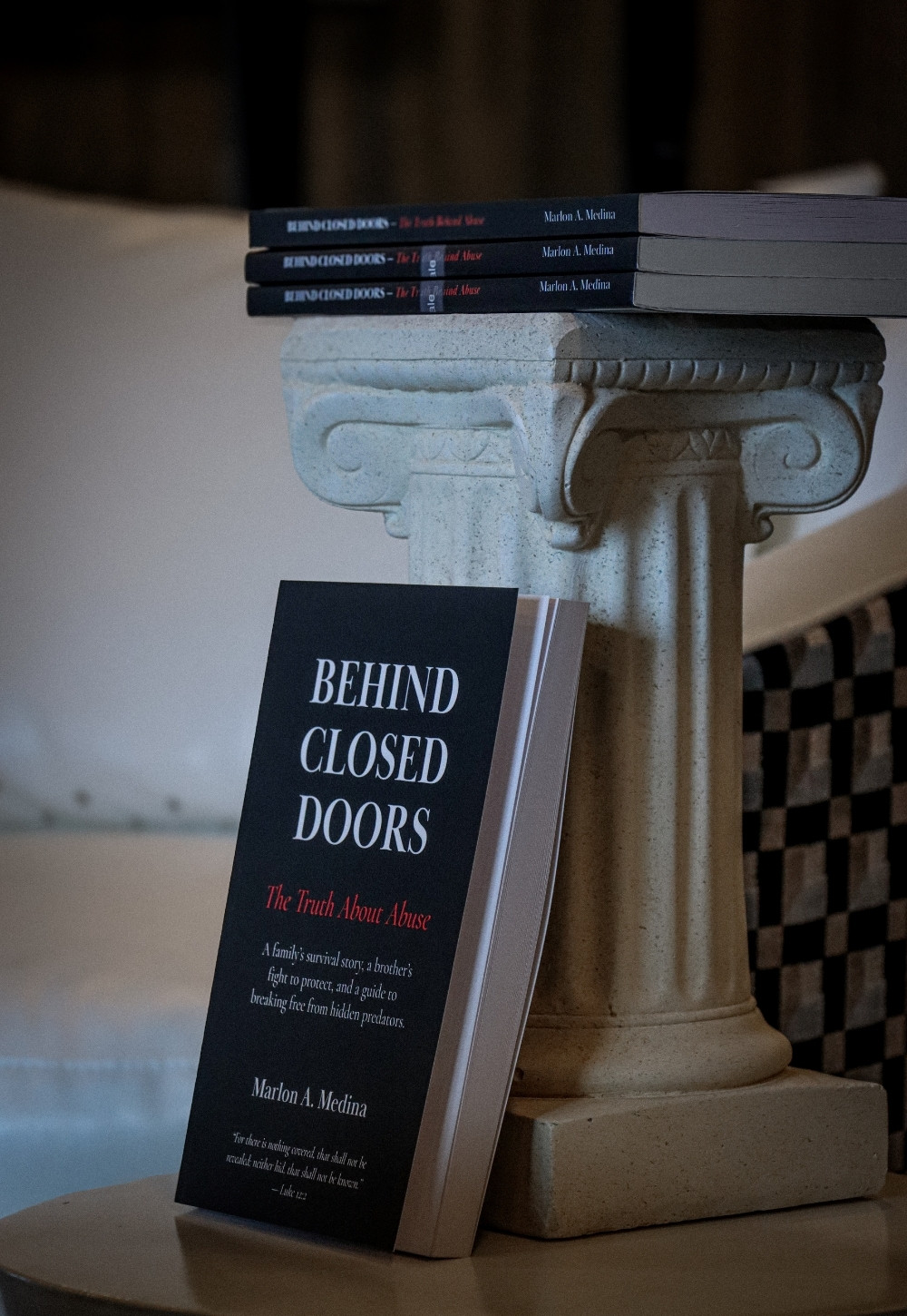 Behind Closed Doors displayed on a classical column indoors