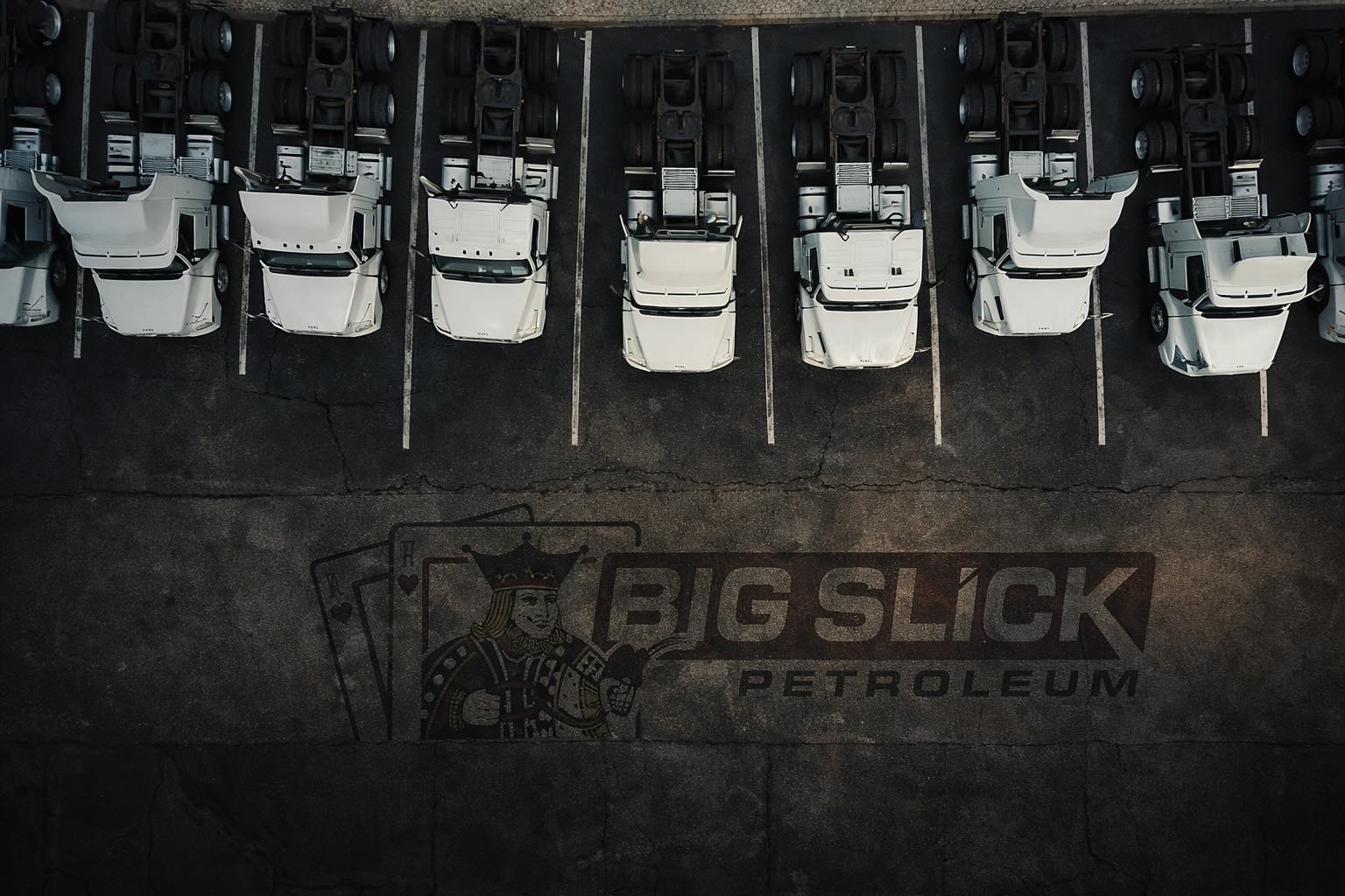 Aerial fleet image featuring the Big Slick Petroleum logo embedded into asphalt with cinematic styling.