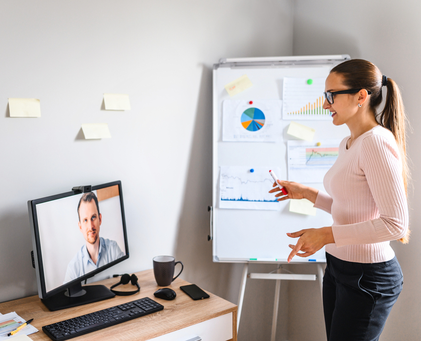 A manager delivering a presentation to colleagues around a boardroom table