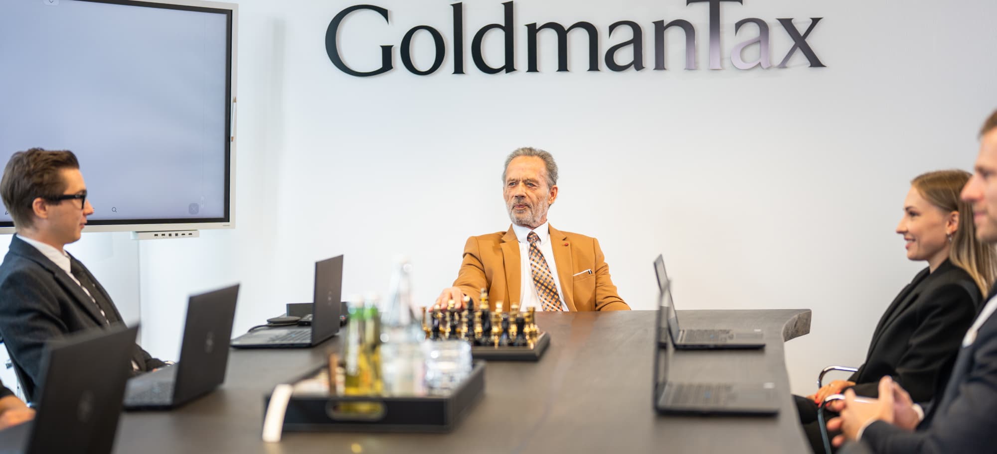 Steuerberater im Meetingraum von GoldmanTax mit Whiteboard und Team