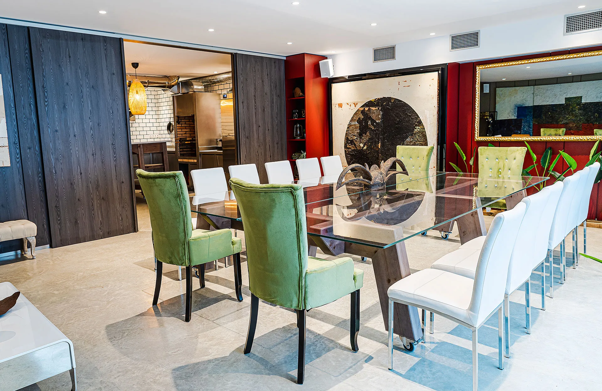 Salón de Sala Baccum con mesa de cristal y sillas blancas y verdes
