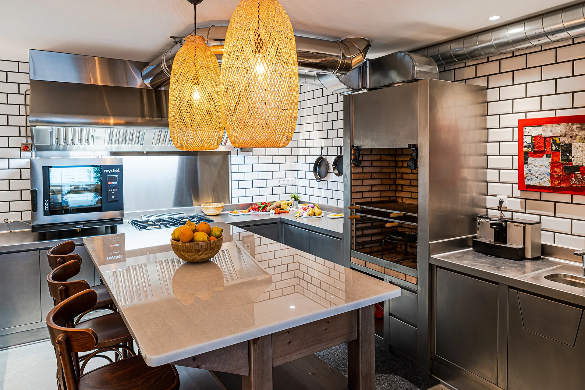 Cocina profesional con isla, horno combinado y barbacoa de carbón