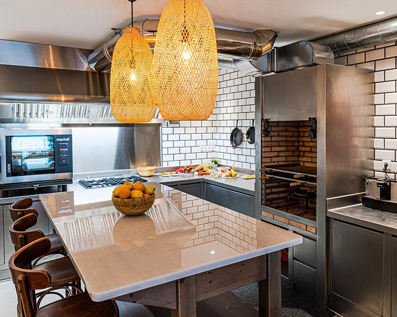 Isla de la cocina con taburetes y lámparas de mimbre