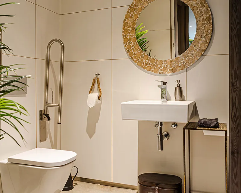 Baño de Sala Baccum con espejo redondo