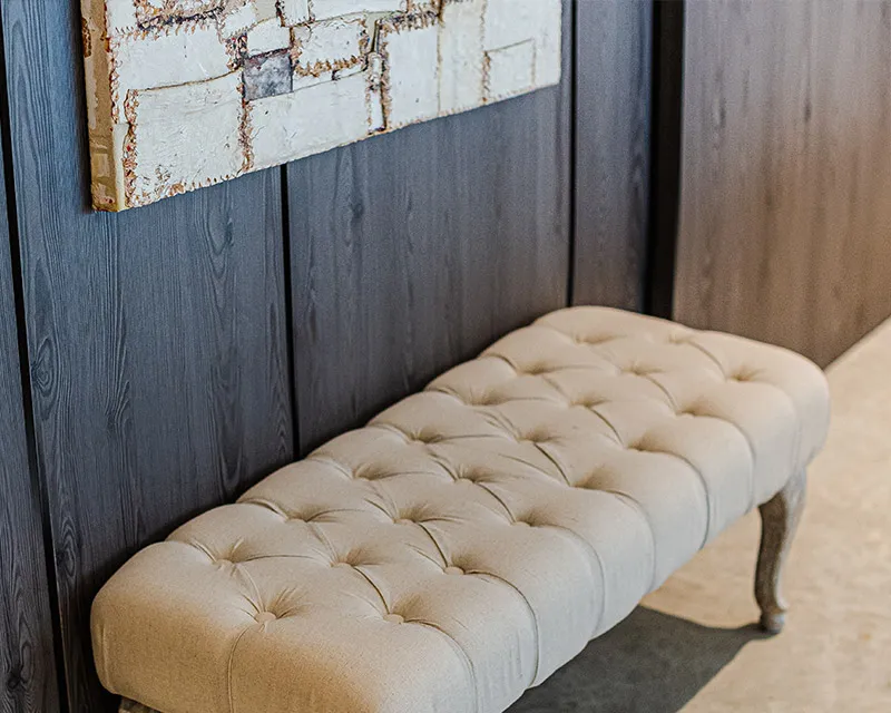 Banc entapissat a l'entrada de la sala