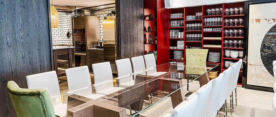 Salón con mesas de cristal y estanterías rojas