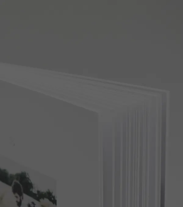 Close-up of a stack of white paper or book pages fanned out on a gray background.
