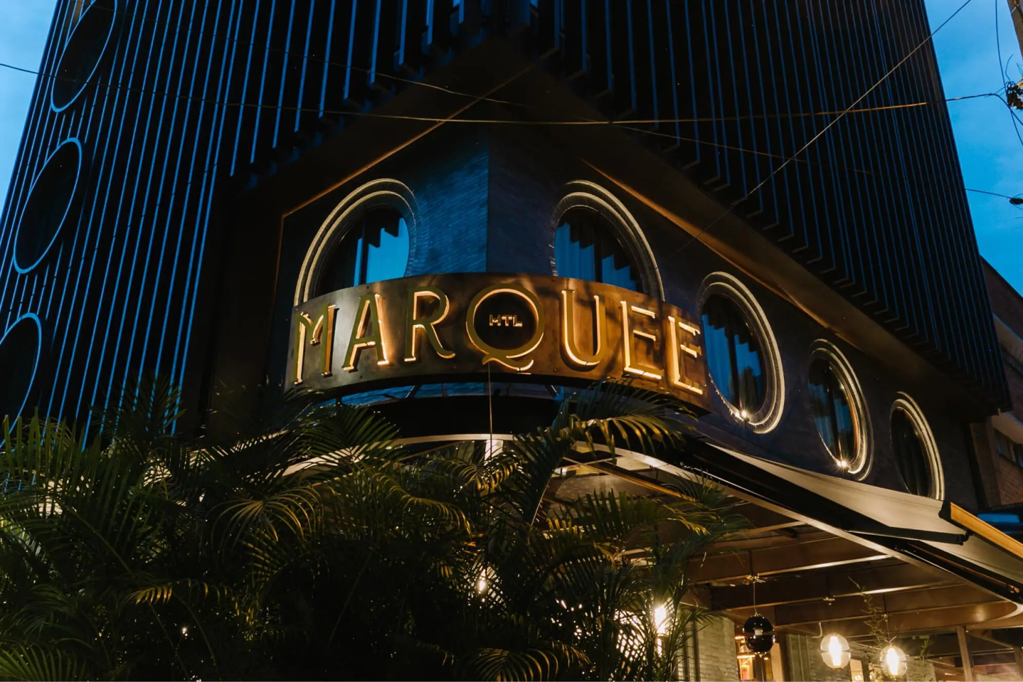 Illuminated Marquee Medellín hotel facade at night in Provenza