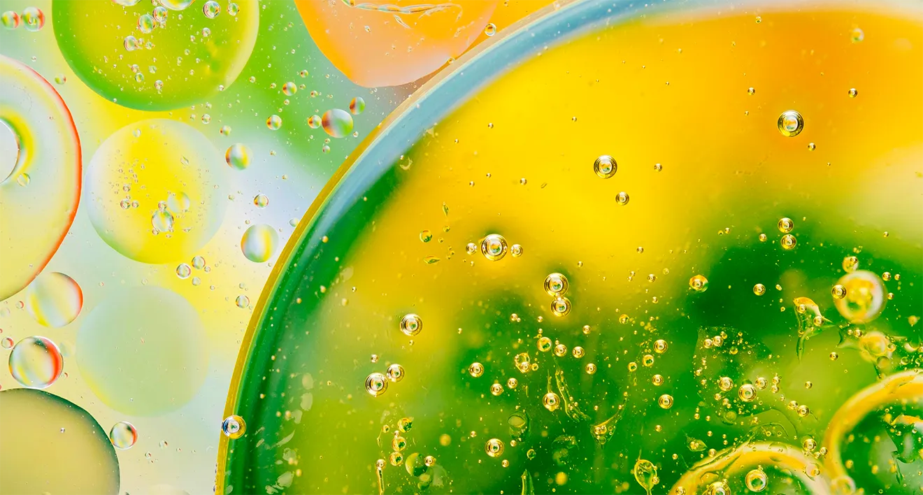Abstract cannabis oil photography featuring fluid textures, droplets, bubbles, and vibrant natural colors.