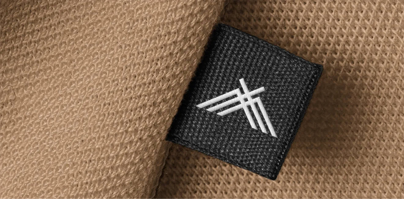 Wakefield Candle Co. merchandise detail featuring embroidered mountain logo on a woven fabric tag