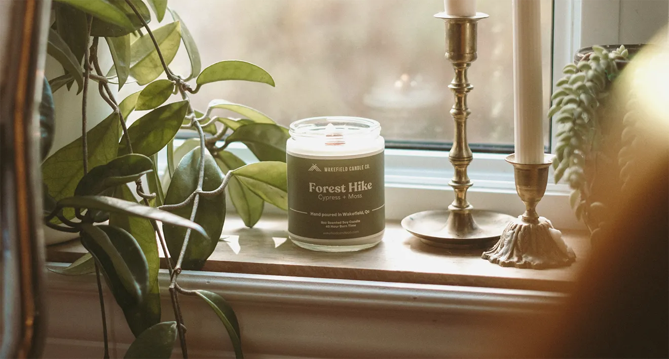 Wakefield Candle Co. Forest Hike candle lifestyle photo featuring green label, plants, and vintage decor.