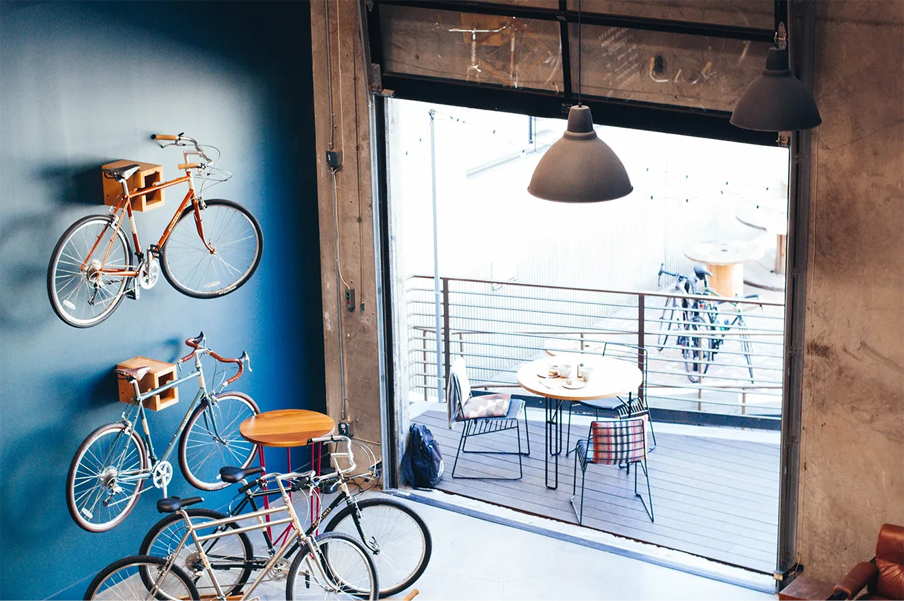 Artizen Kombucha retail photography featuring a cafe and bike shop partner environment with branded lifestyle styling.