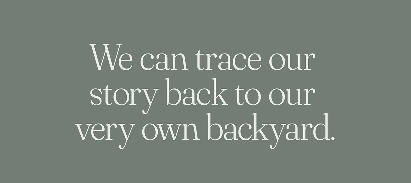 Ambiance Botanique brand slogan, 'We can trace our story back to our very own backyard,' on a sage green background.