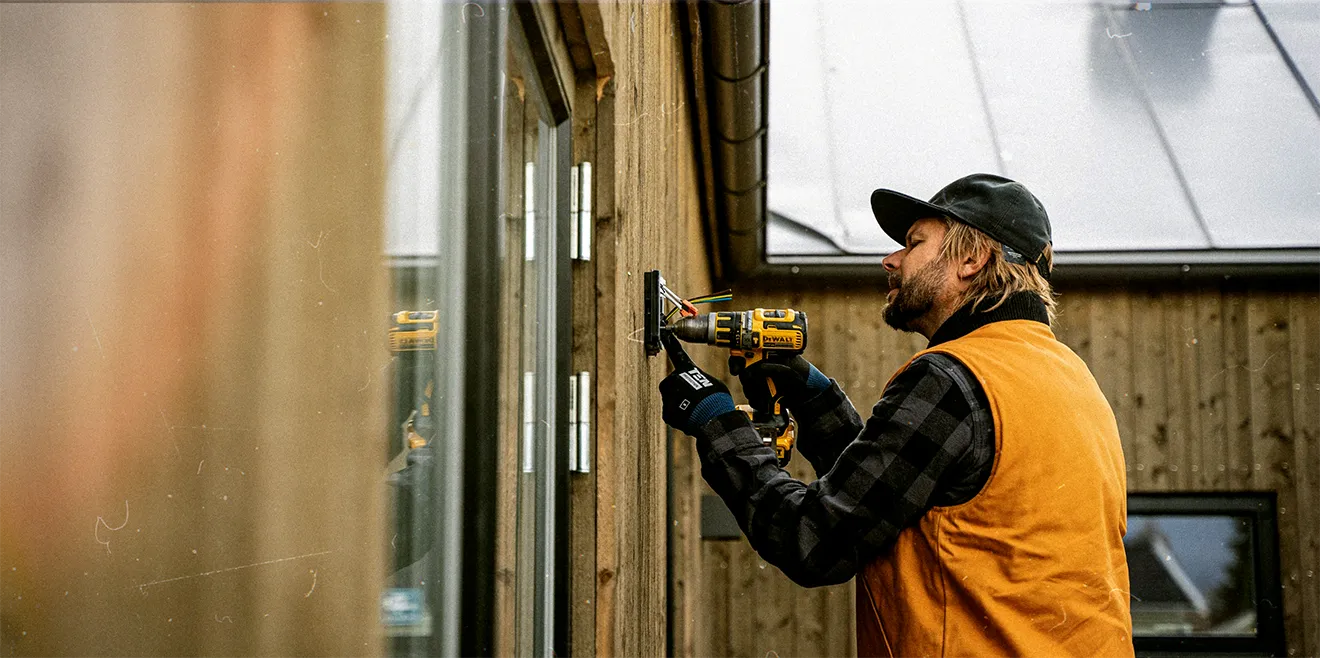 Plateau Electric Co. brand photography showing electrician holding electrical cable with rugged utility styling.