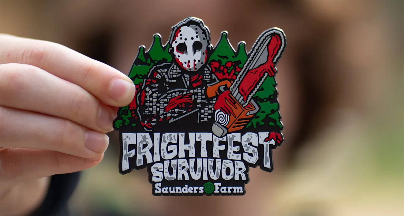 Hand holding custom 3D rubber Frightfest Survivor souvenir magnet, designed for Saunders Farm by Hovski Studio.