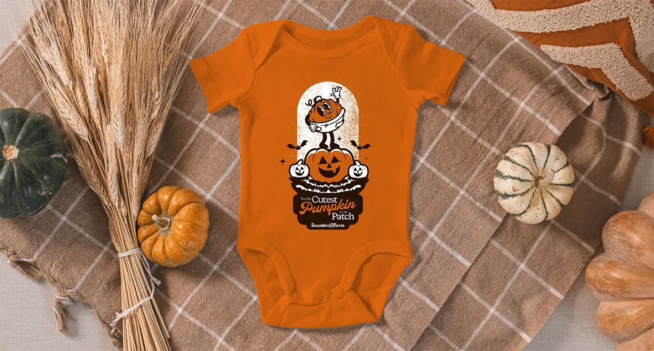 Orange infant onesie mockup with retro pumpkin mascot illustration for Saunders Farm PumpkinFest, by Hovski Studio.