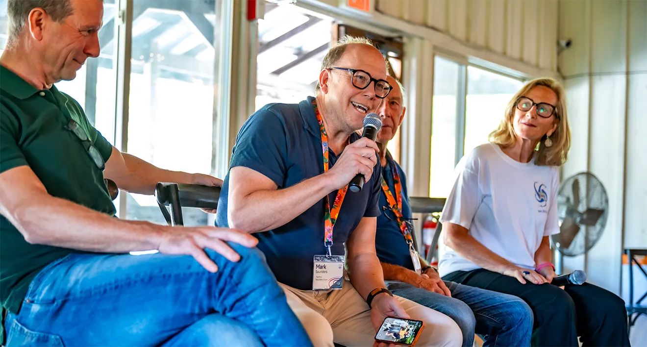 Mark Saunders speaking during a family panel discussion inside the Saunders Farm Pavilion.