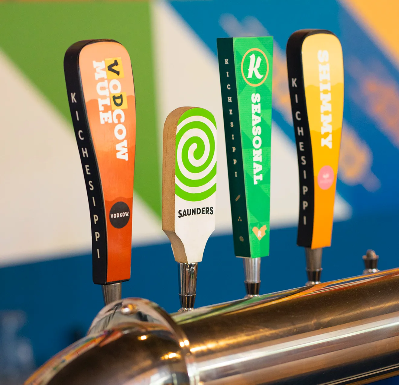 Wood-grained Saunders Cider tap handle with green and white spiral logo at Kitchissippi brewery in Ottawa.