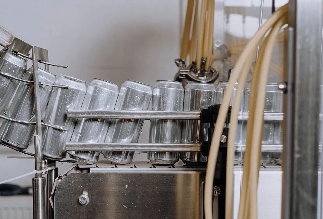 Commercial automated canning line filling aluminum cans inside modern Saunders Cider beverage production facility.