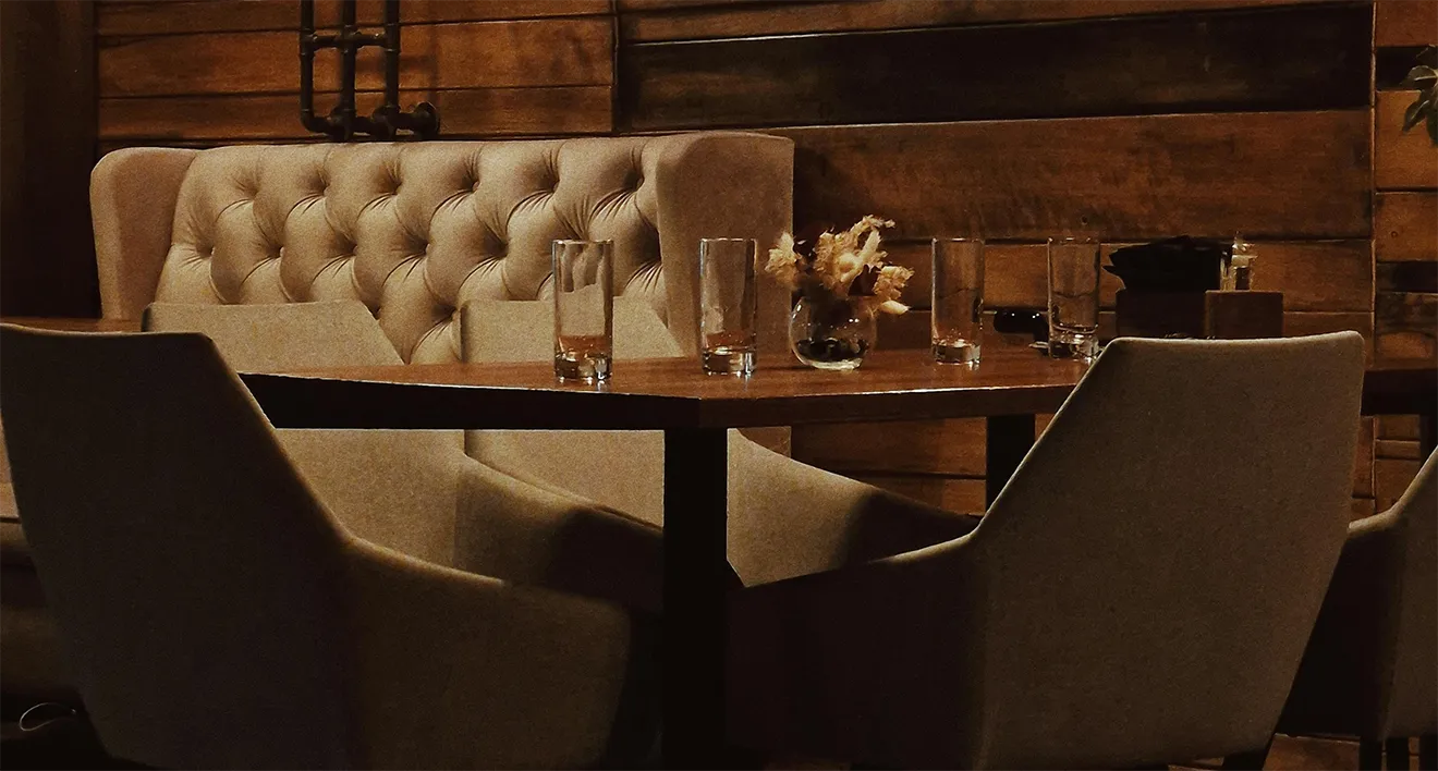 Custom long wood dining table and leather seating interior for Donahue Furniture.