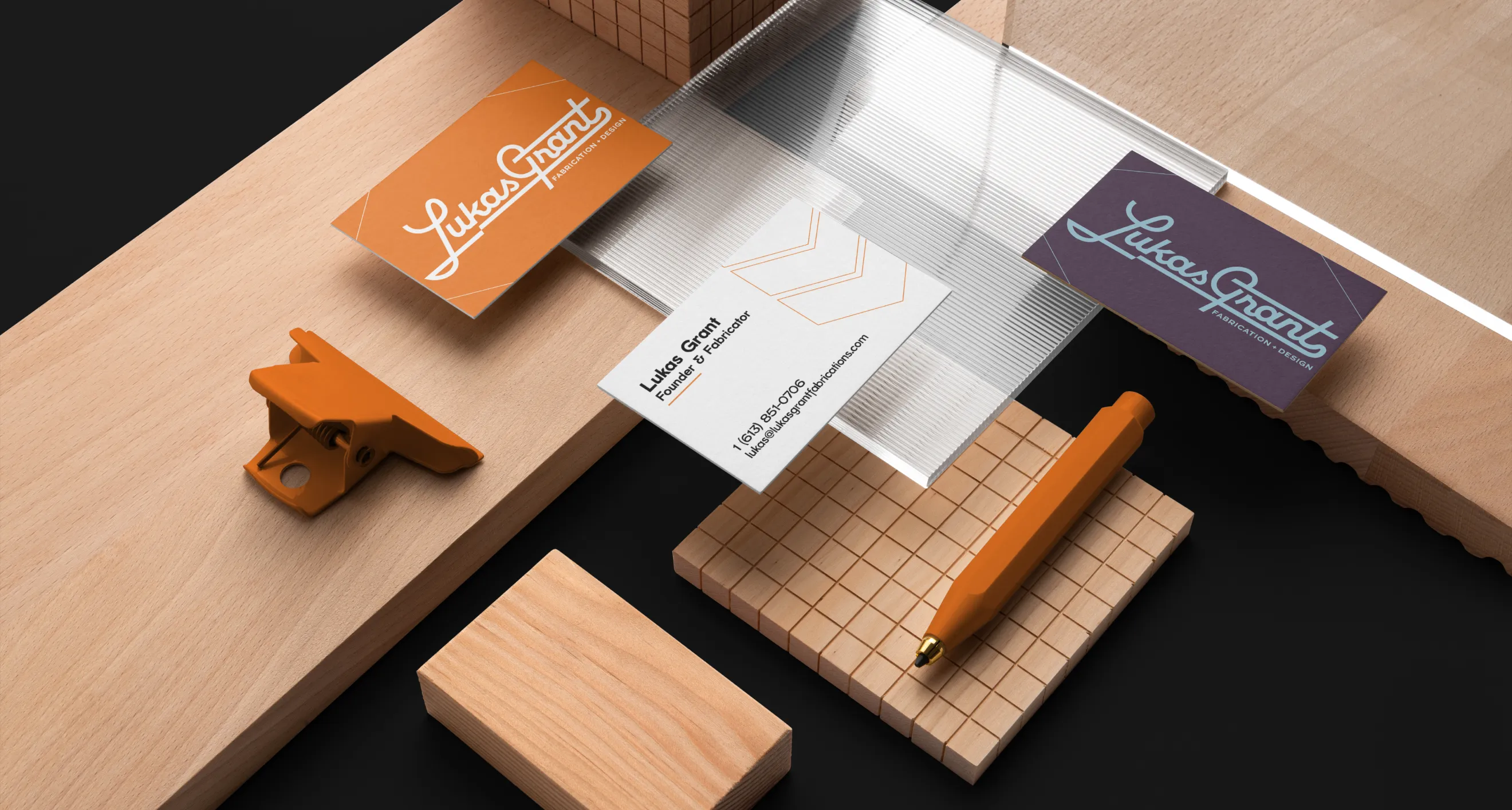Brand material presentation with business cards, wood blocks, and orange accessories by Hovski Studio.