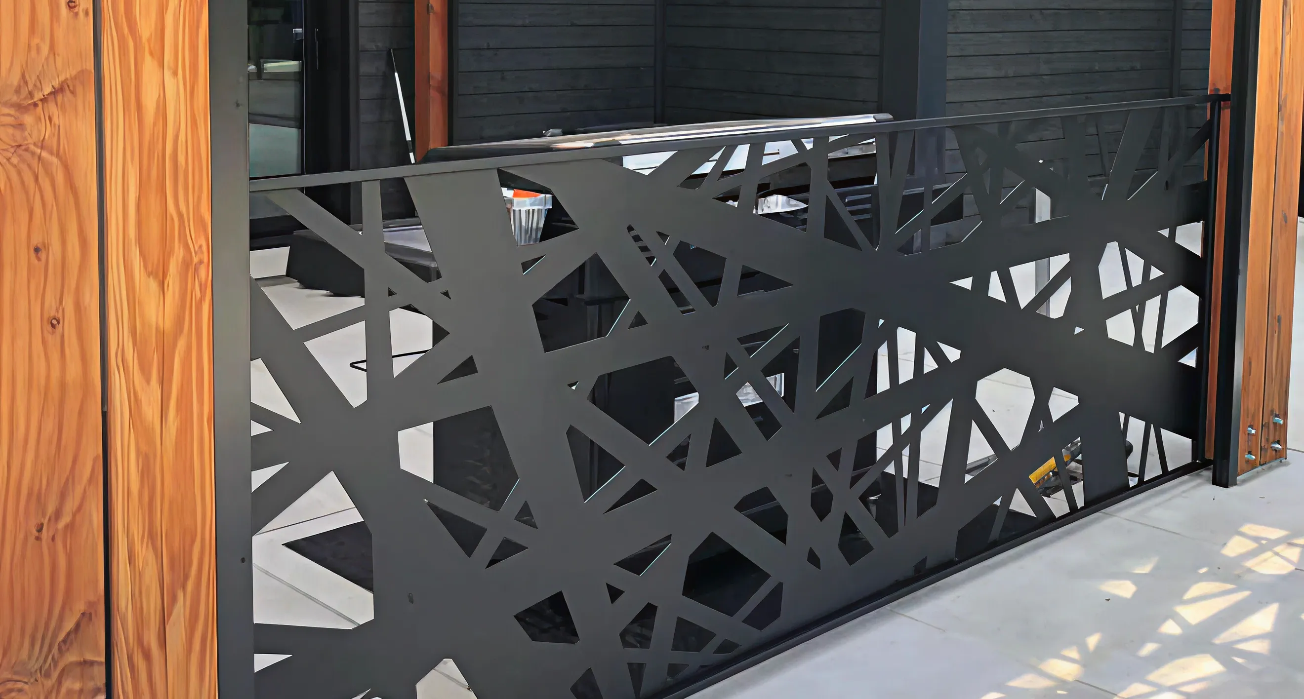 Geometric laser-cut black metal patio screen and railing panel by Lukas Grant Fabrication.