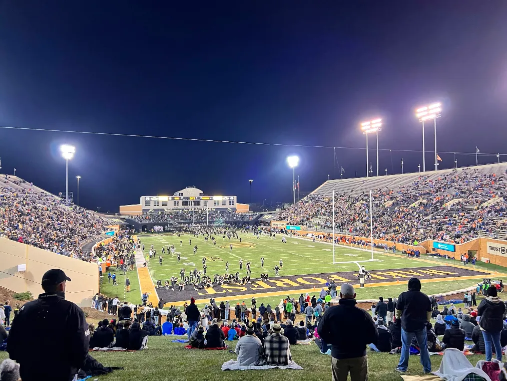 Packed stadium under the lights at a Wake Forest football game