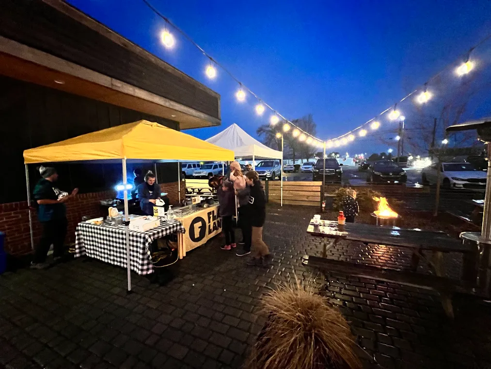 Flatland tent under string lights at a night event